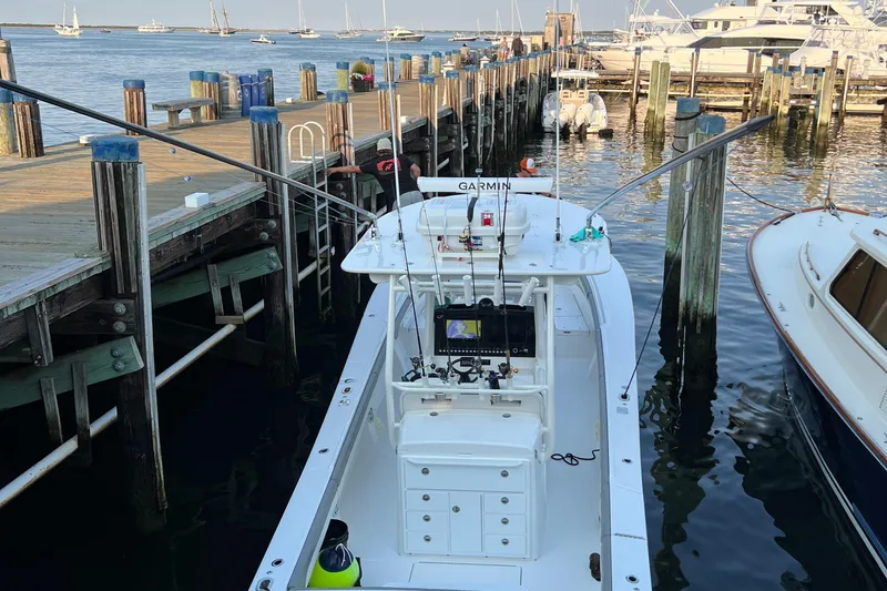  Yacht Photos Pics 2022 Regulator 34 boat docked at a marina, equipped with fishing gear and Garmin electronics.