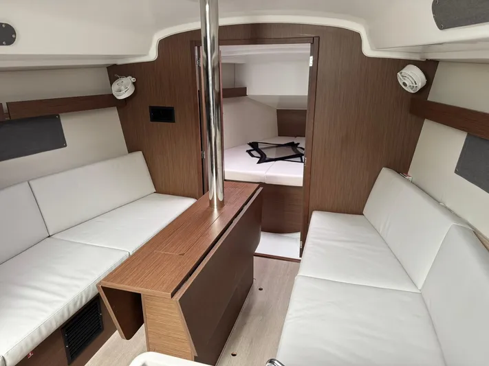 Xanadu Yacht Photos Pics 2024 Beneteau Oceanis 34.1 interior with white seating and wood accents.