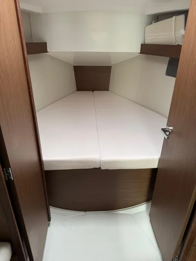 Xanadu Yacht Photos Pics 2024 Beneteau Oceanis 34.1 cabin interior with cozy bed and wooden finish.