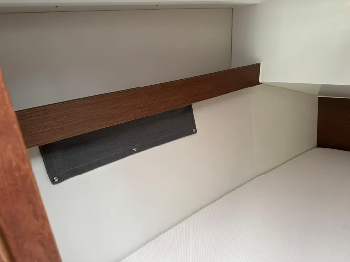 Xanadu Yacht Photos Pics Interior cabin of 2024 Beneteau Oceanis 34.1 sailboat, featuring sleek wood and fabric design.