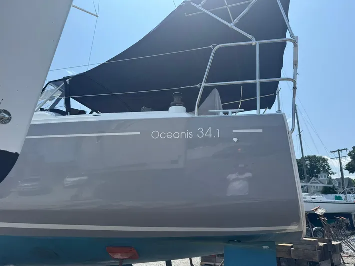 Xanadu Yacht Photos Pics 2024 Beneteau Oceanis 34.1 sailboat with dark canopy, docked outdoors.