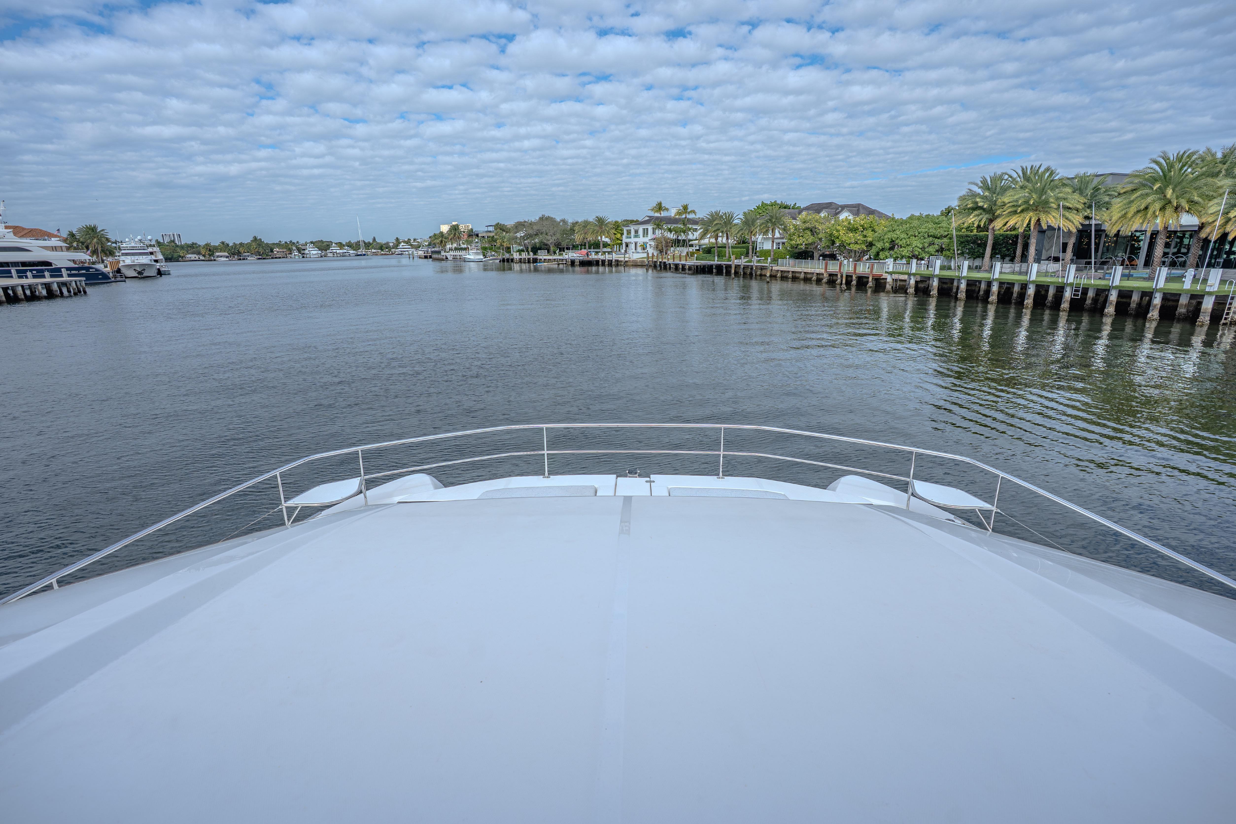 Bow view of 2025 Leopard 53 Powercat on a calm waterway under a cloudy sky.