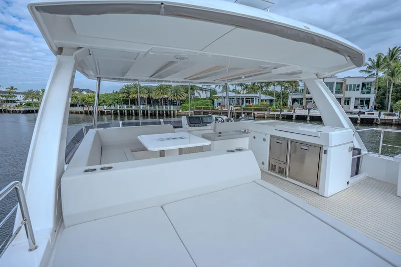 Althea Yacht Photos Pics 2025 Leopard 53 Powercat yacht interior with seating, table, and kitchenette by the water.