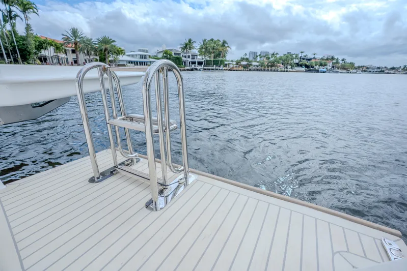 Althea Yacht Photos Pics 2025 Leopard 53 Powercat swim platform with stainless steel ladder, overlooking serene waterfront.