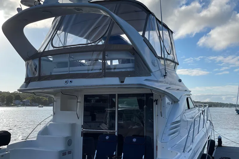  Yacht Photos Pics 2000 Sea Ray 400 Sedan Bridge yacht docked by the water under a partly cloudy sky.