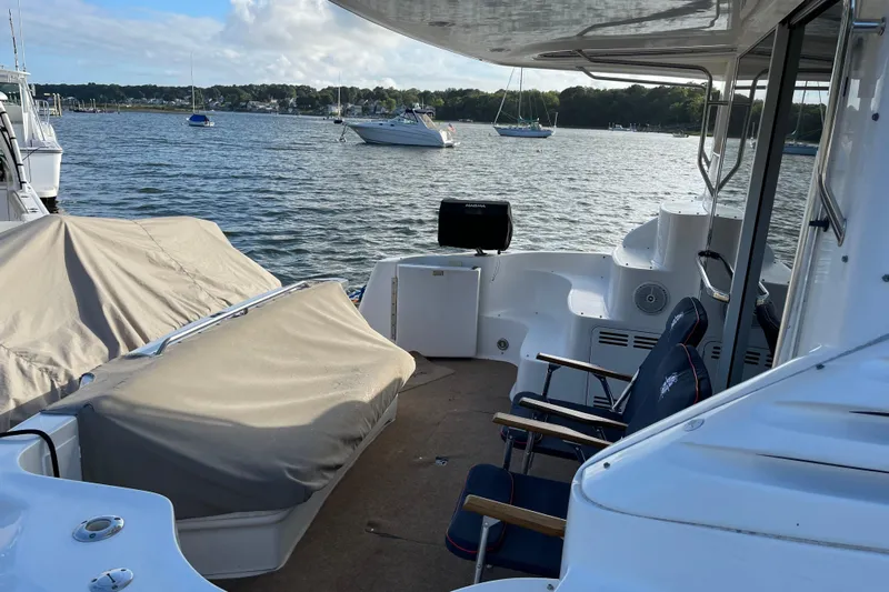  Yacht Photos Pics 2000 Sea Ray 400 Sedan Bridge yacht interior with covered seating, overlooking a serene marina.