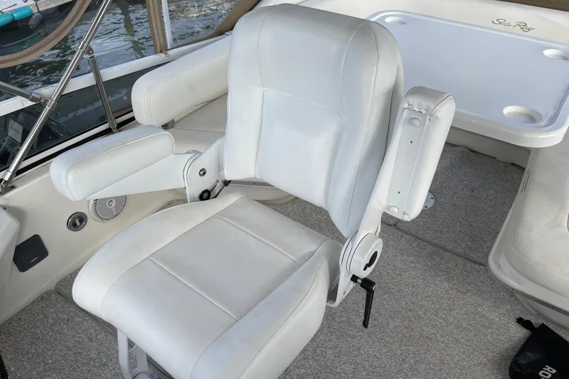  Yacht Photos Pics White captain's chair on 2000 Sea Ray 400 Sedan Bridge yacht, with armrests and carpeted deck.