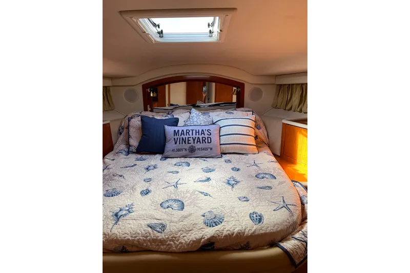  Yacht Photos Pics Cozy bedroom in 2000 Sea Ray 400 Sedan Bridge with nautical-themed bedding.
