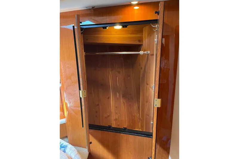  Yacht Photos Pics Open wooden closet inside 2000 Sea Ray 400 Sedan Bridge yacht, featuring interior lighting.