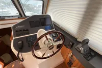 2023 Elling E4 yacht helm with modern navigation controls and wooden steering wheel.