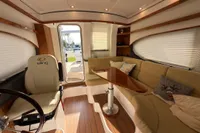 Luxurious interior of 2023 Elling E4 yacht with plush seating and elegant wood finishes.