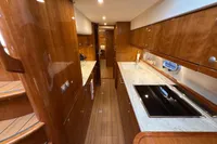 Luxurious 2023 Elling E4 yacht interior with sleek wooden cabinetry and modern kitchen amenities.