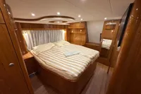 Luxurious 2023 Elling E4 yacht bedroom with elegant wood finish and cozy bedding.