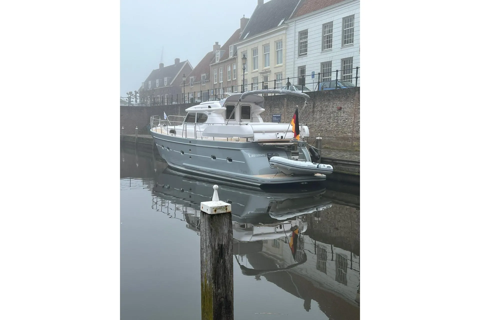2023 Elling E4 yacht docked in a serene canal, reflecting historic buildings.