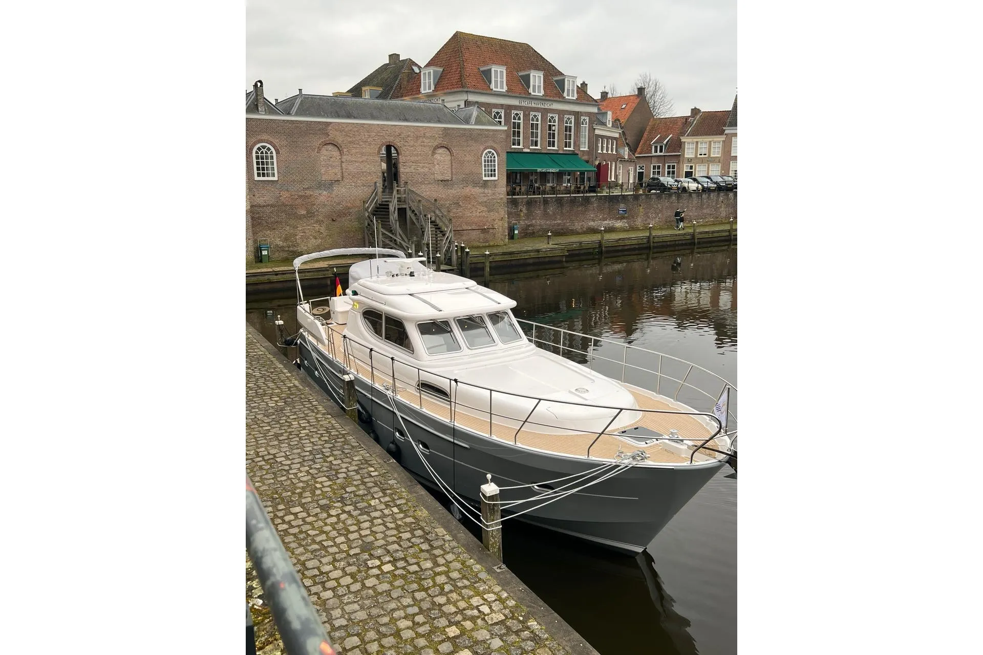 2023 Elling E4 yacht docked by historic brick buildings.