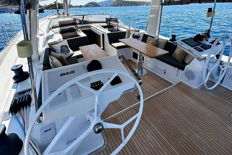 Nil Yacht Photos Pics Luxurious 2024 Hanse 588 yacht deck with dual steering wheels and elegant seating area.