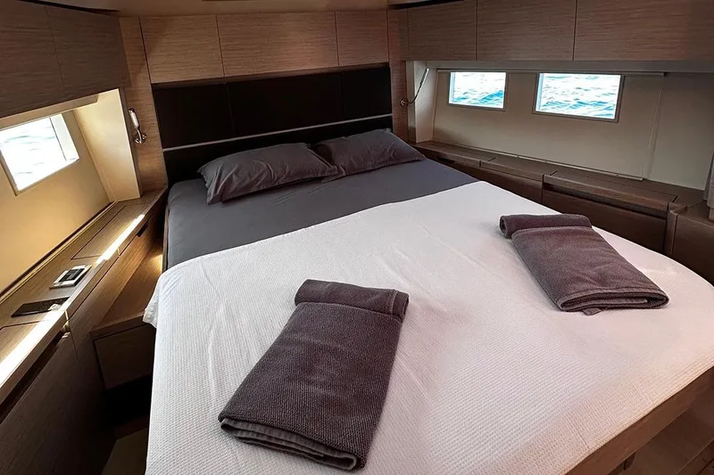 Nil Yacht Photos Pics Luxurious 2024 Hanse 588 yacht cabin with elegant bedding and ocean view windows.