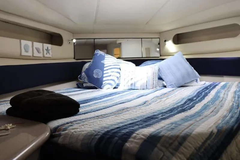  Yacht Photos Pics Cozy cabin interior of 1999 Sea Ray Sundancer 50 with striped bedding and nautical decor.