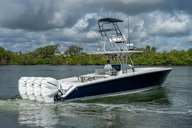  Yacht Photos Pics 2005 Venture 39 Open boat cruising on a river with four Mercury outboard engines.