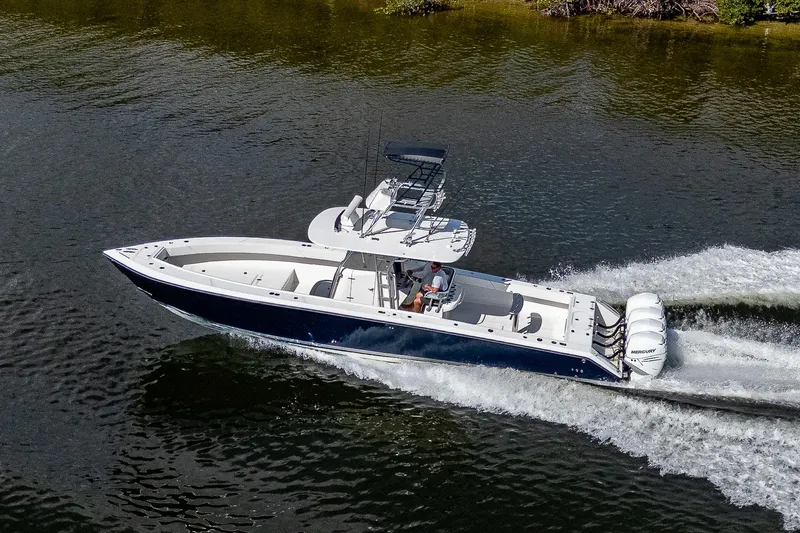  Yacht Photos Pics 2005 Venture 39 Open boat cruising on water with triple outboard engines.