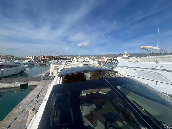  Yacht Photos Pics Luxurious 2010 Atlantis 55 yacht docked in a sunny marina, surrounded by other boats.