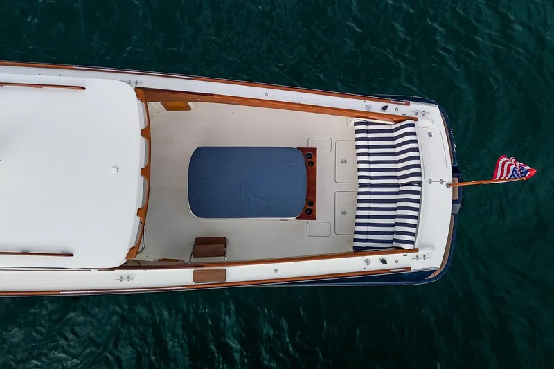 Seaker Yacht Photos Pics Aerial view of 2001 Hinckley Picnic Boat Classic on water, featuring striped seating and American flag.