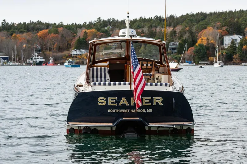 Seaker Yacht Photos Pics Hinckley Picnic Boat Classic 2001 on water, displaying American flag, autumn trees in background.