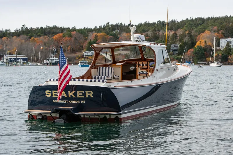 Seaker Yacht Photos Pics 2001 Hinckley Picnic Boat Classic on water, American flag, autumn trees in background.