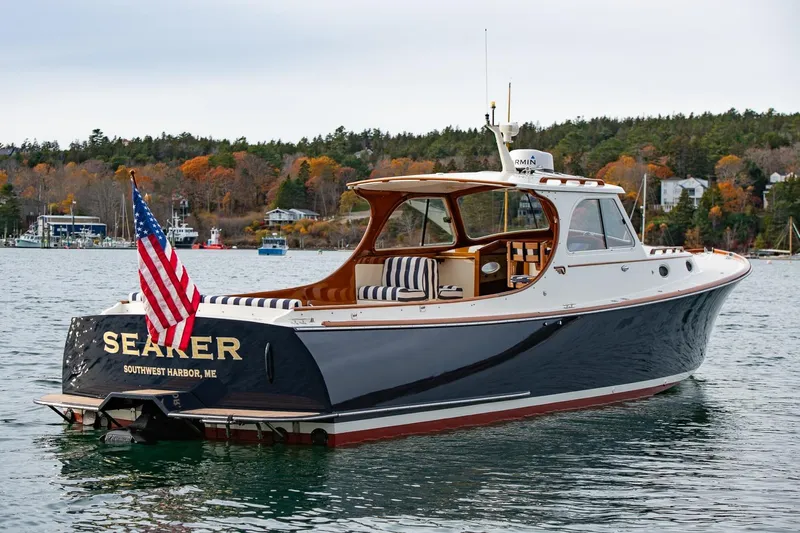 Seaker Yacht Photos Pics 2001 Hinckley Picnic Boat Classic on water, American flag, autumn shoreline background.