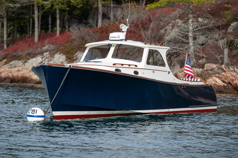 Seaker Yacht Photos Pics 2001 Hinckley Picnic Boat Classic on water, American flag, scenic background.
