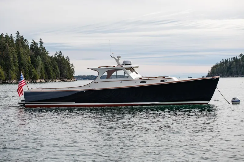 Seaker Yacht Photos Pics 2001 Hinckley Picnic Boat Classic on calm water, surrounded by trees.