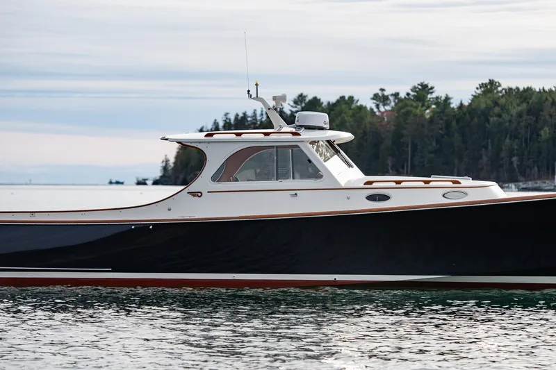 Seaker Yacht Photos Pics 2001 Hinckley Picnic Boat Classic on calm water with forested shoreline background.