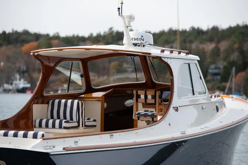 Seaker Yacht Photos Pics 2001 Hinckley Picnic Boat Classic with striped seating, docked on a serene lake.