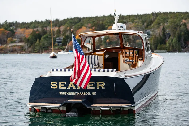 Seaker Yacht Photos Pics 2001 Hinckley Picnic Boat Classic on water, displaying American flag, Southwest Harbor, ME.