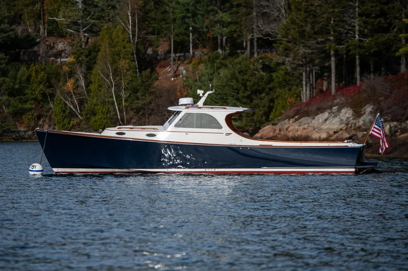 Seaker Yacht Photos Pics 2001 Hinckley Picnic Boat Classic on serene water, surrounded by lush greenery.