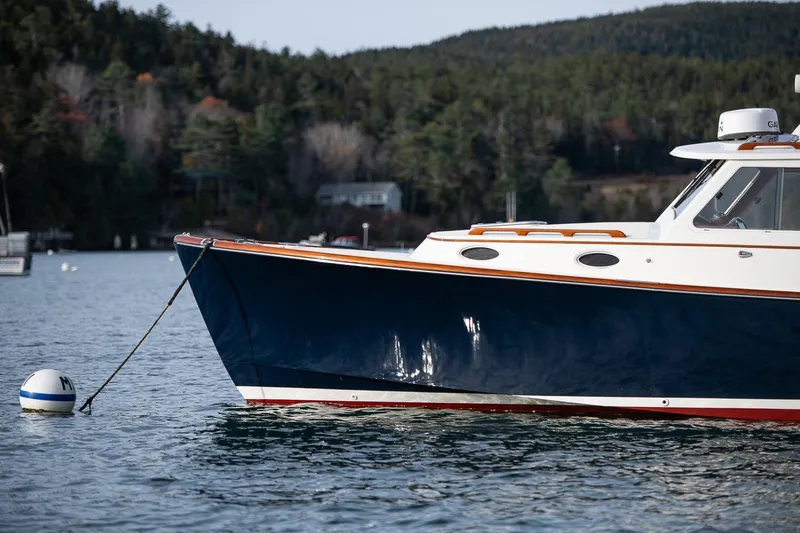 Seaker Yacht Photos Pics 2001 Hinckley Picnic Boat Classic moored on calm water with forested background.