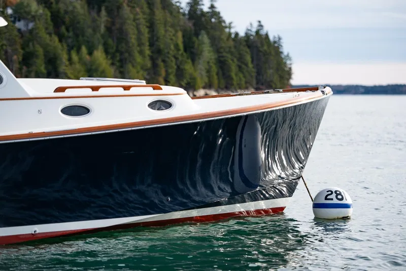 Seaker Yacht Photos Pics 2001 Hinckley Picnic Boat Classic on water near forested shoreline.