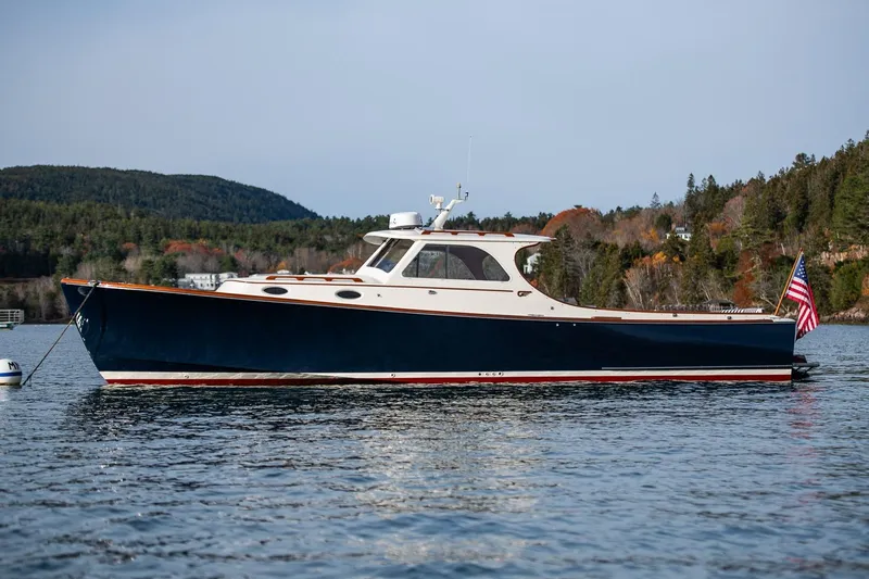 Seaker Yacht Photos Pics 2001 Hinckley Picnic Boat Classic on scenic lake with forested hills in background.