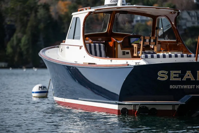 Seaker Yacht Photos Pics 2001 Hinckley Picnic Boat Classic on serene water, featuring elegant design and striped seating.