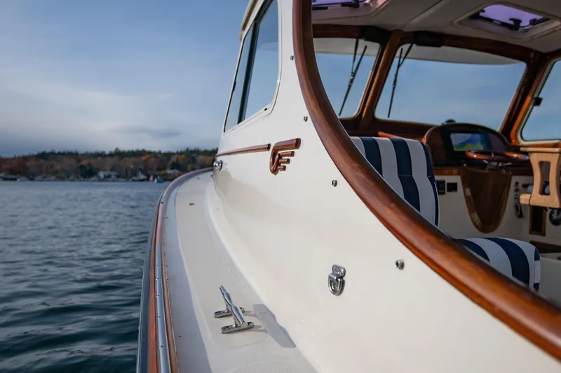 Seaker Yacht Photos Pics 2001 Hinckley Picnic Boat Classic with striped seating, cruising on calm waters.