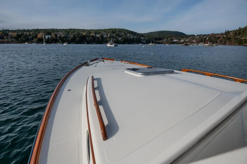 Seaker Yacht Photos Pics 2001 Hinckley Picnic Boat Classic cruising on a serene lake with forested shoreline.