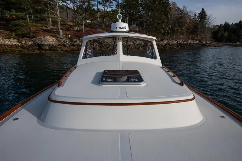 Seaker Yacht Photos Pics 2001 Hinckley Picnic Boat Classic on calm water near rocky shoreline.