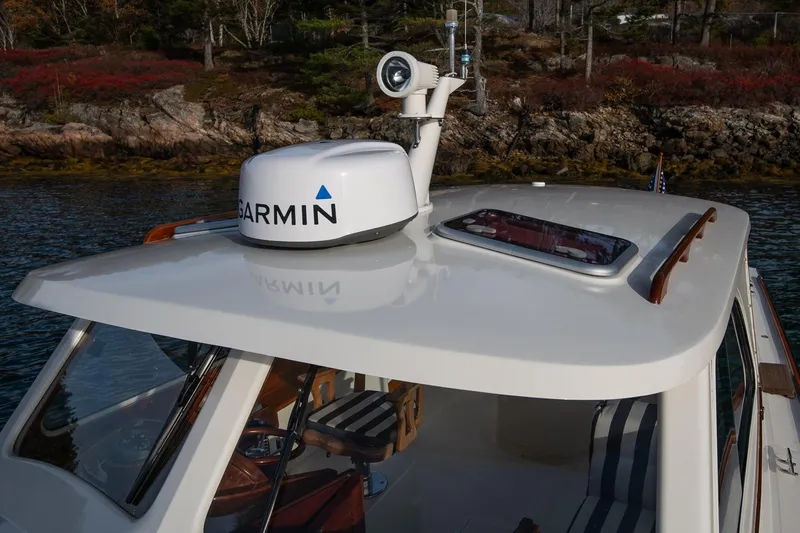 Seaker Yacht Photos Pics 2001 Hinckley Picnic Boat Classic with Garmin radar, docked near rocky shoreline.
