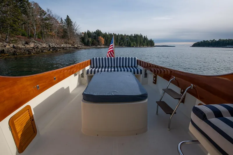 Seaker Yacht Photos Pics 2001 Hinckley Picnic Boat Classic with striped seating, cruising on a serene lake.
