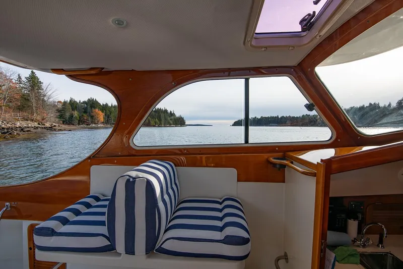 Seaker Yacht Photos Pics Interior view of 2001 Hinckley Picnic Boat Classic with striped seating and scenic waterway.