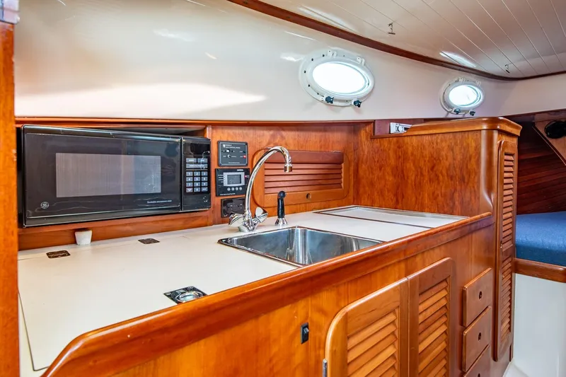 Seaker Yacht Photos Pics Hinckley Picnic Boat Classic 2001 interior with wooden cabinetry, sink, and microwave.