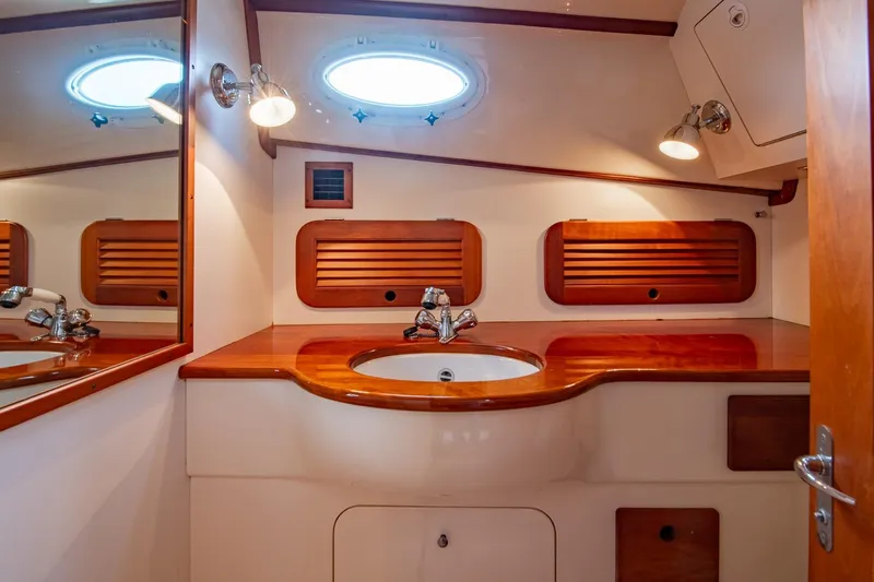 Seaker Yacht Photos Pics 2001 Hinckley Picnic Boat Classic bathroom with wooden accents and round porthole window.