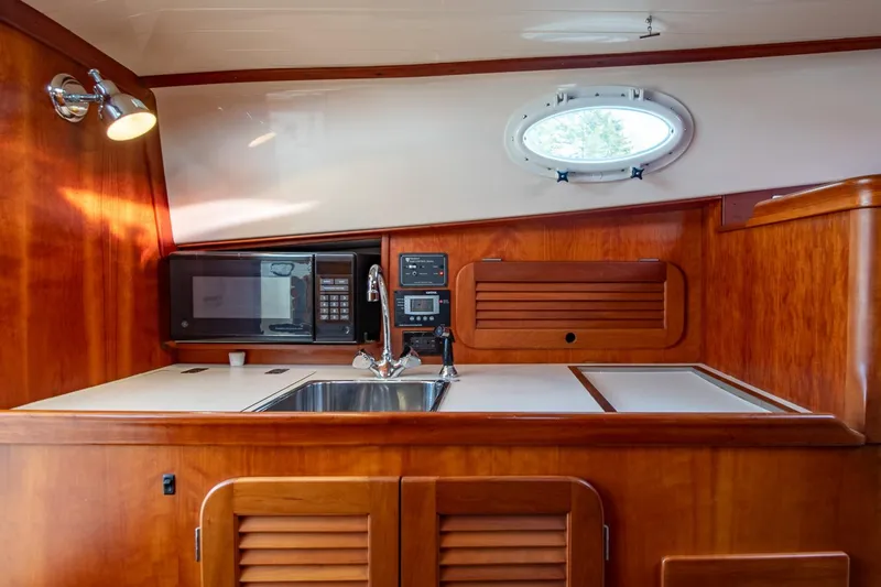 Seaker Yacht Photos Pics 2001 Hinckley Picnic Boat Classic interior with wooden cabinetry, sink, and microwave.