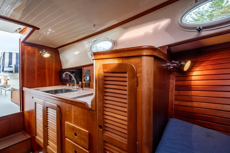 Seaker Yacht Photos Pics Interior of 2001 Hinckley Picnic Boat Classic with wooden cabinetry and compact kitchen area.