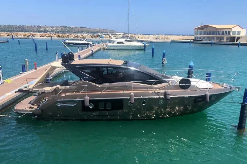  Yacht Photos Pics 2019 Cranchi M 44 HT yacht docked in a marina, surrounded by clear blue water.